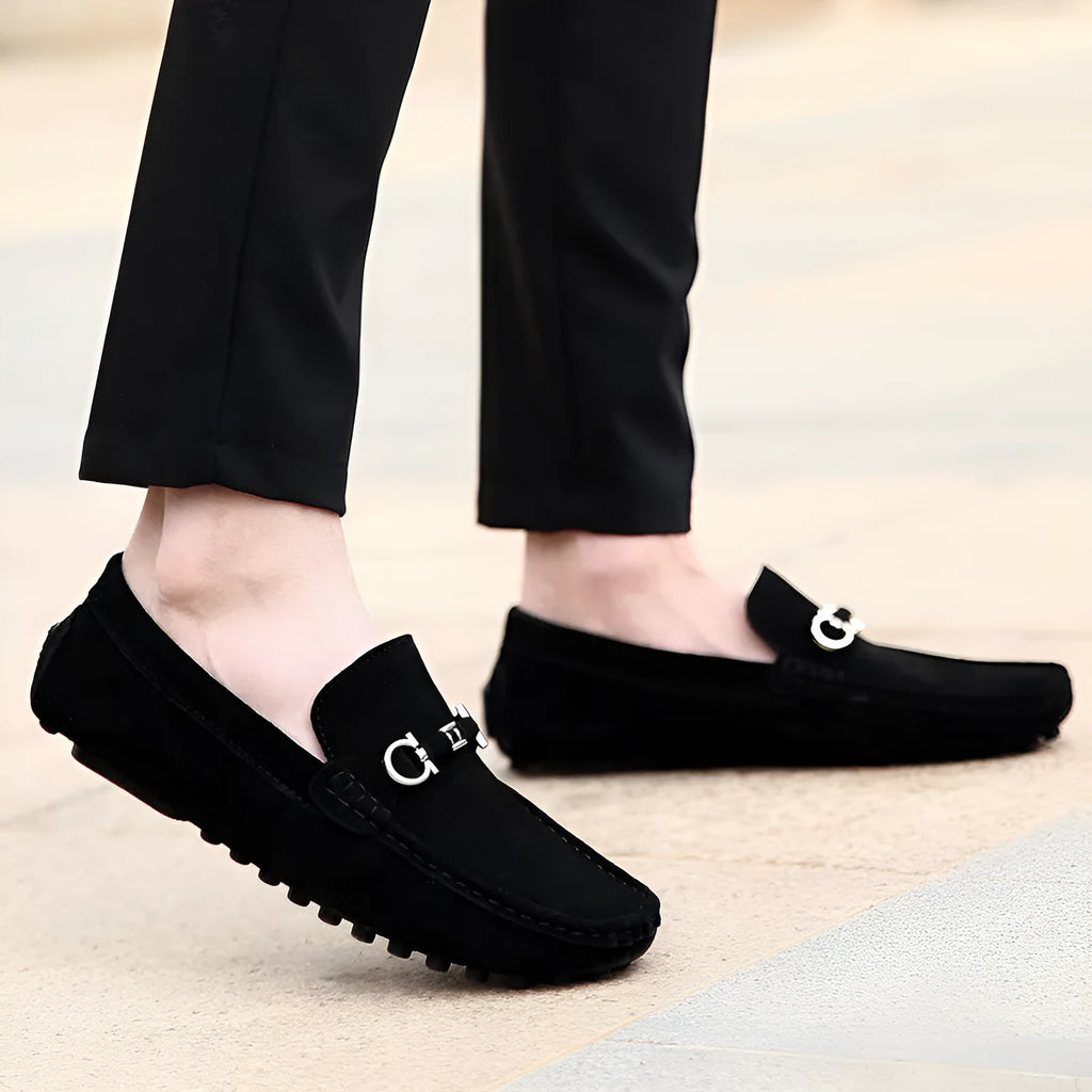 Men's black matte cowhide slip-on shoe with square toe and visible stitching on a plain background.