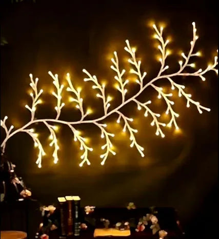 Flexible plastic willow vine LED garland light with warm white bulbs and birch bark texture.