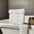 White adult bathtub pillow with 4D mesh material and suction cups on a bath mat.