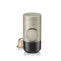 Manual espresso portable capsule coffee machine in olive gray with resin body, 129x70x60mm, on outdoor background