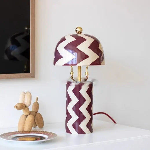 Striped table lamp with matte finish, pushbutton switch, and UK plug on a desk