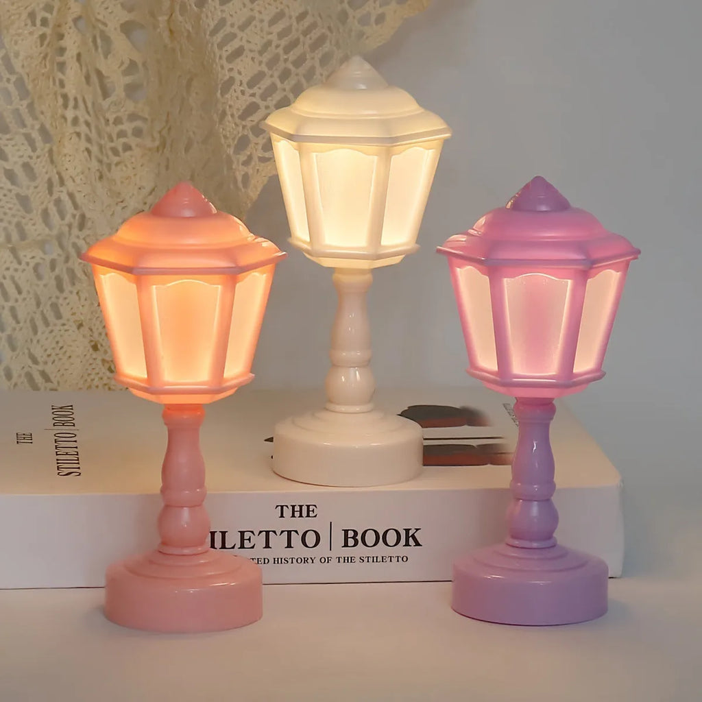 Small geometric retro pagoda night lamp in light purple, shown on a wooden surface.