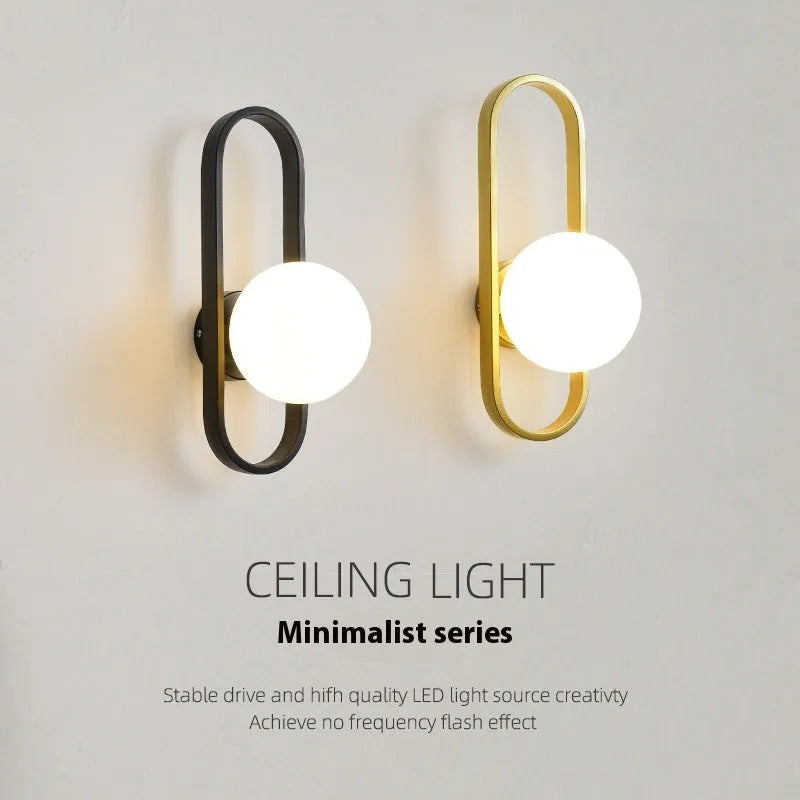 Minimalist wall-mounted lamp with glass shade and iron body in black or gold finish, showing 12W tri-colour LED light.