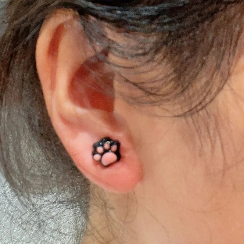 Cat paw magnetic ear clips in transparent pink colour with plastic resin finish, packaged as one pair