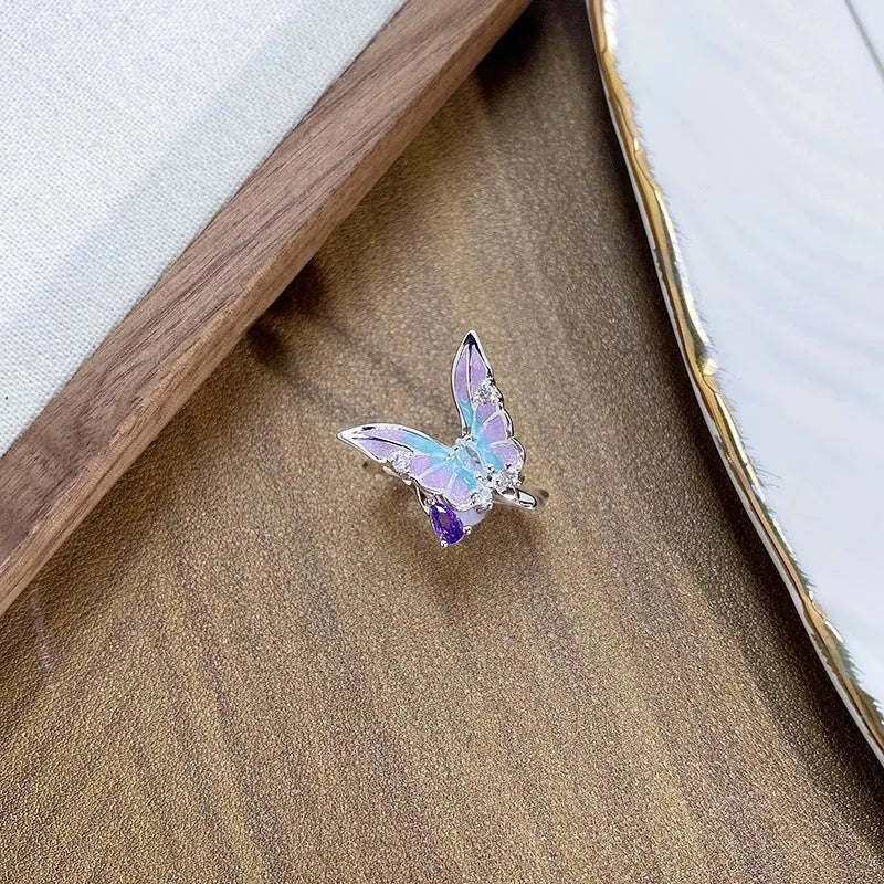 Close-up of an adjustable copper ring with an insect design and a textured dripping oil finish.