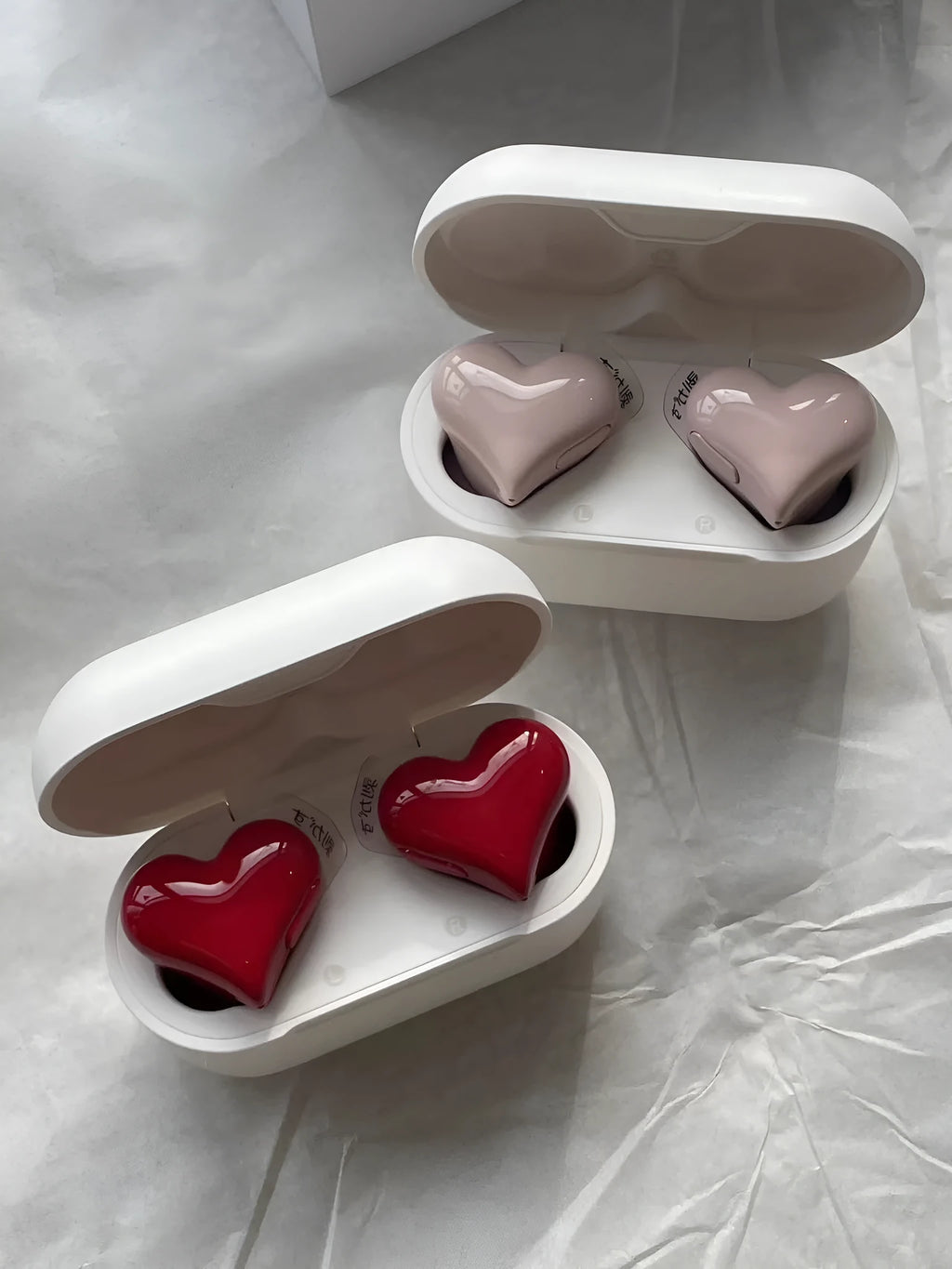 Heart-shaped wireless Bluetooth in-ear headphones in girl pink with charging cable