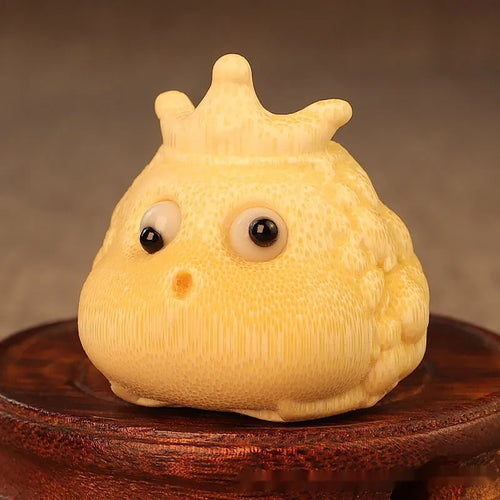Solid bamboo carving of a cute Crown Princess toad ornament on a wooden surface.
