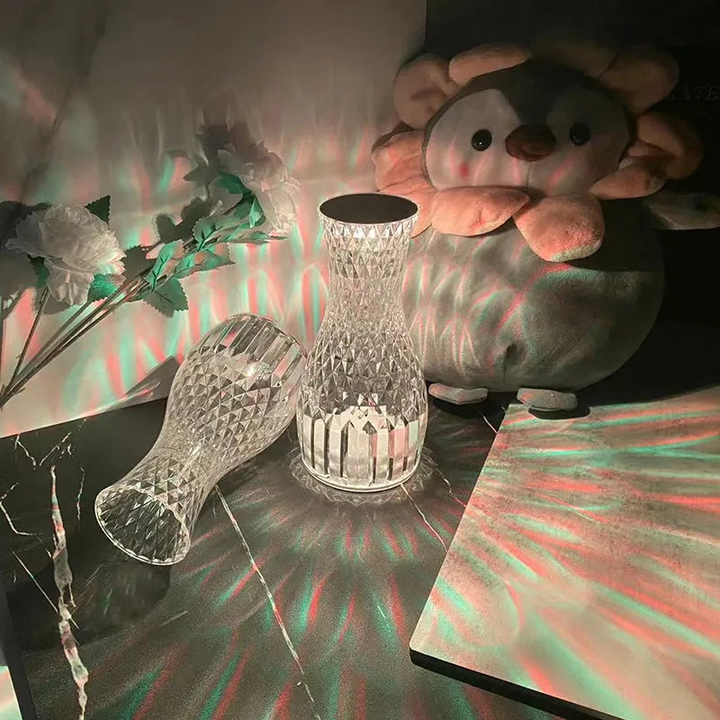 Vase-shaped crystal table lamp with LED lights and remote control on a bedside table