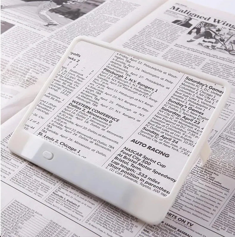 Black illuminated magnifying glass with 3x magnification and LED reading light on white background