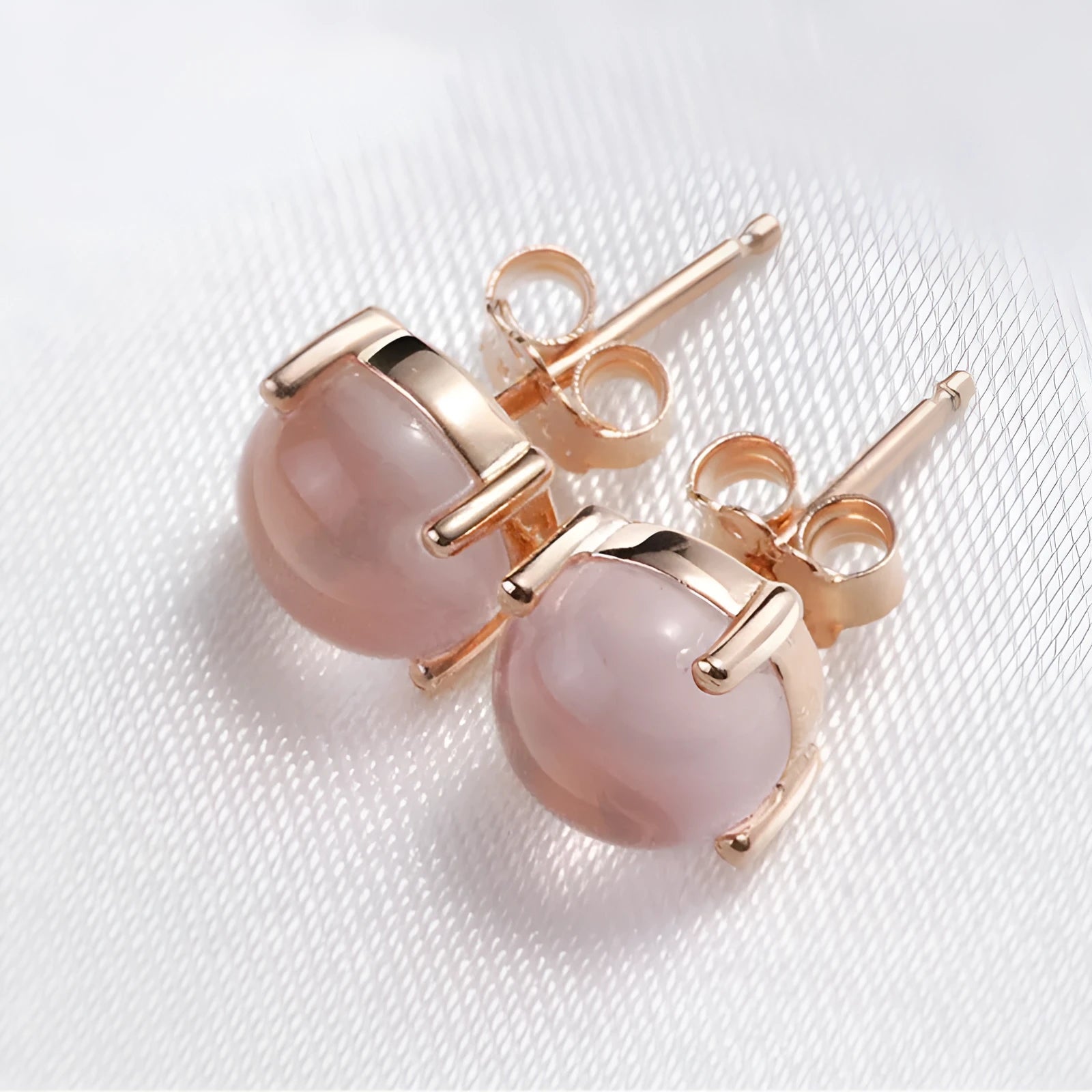 Rose gold drop shape stud earrings with crystal inlay detail on a silver base.