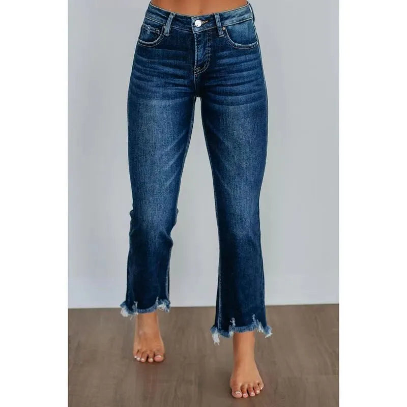 A pair of women's solid colour denim trousers with a manual wear finish, shown in dark blue.