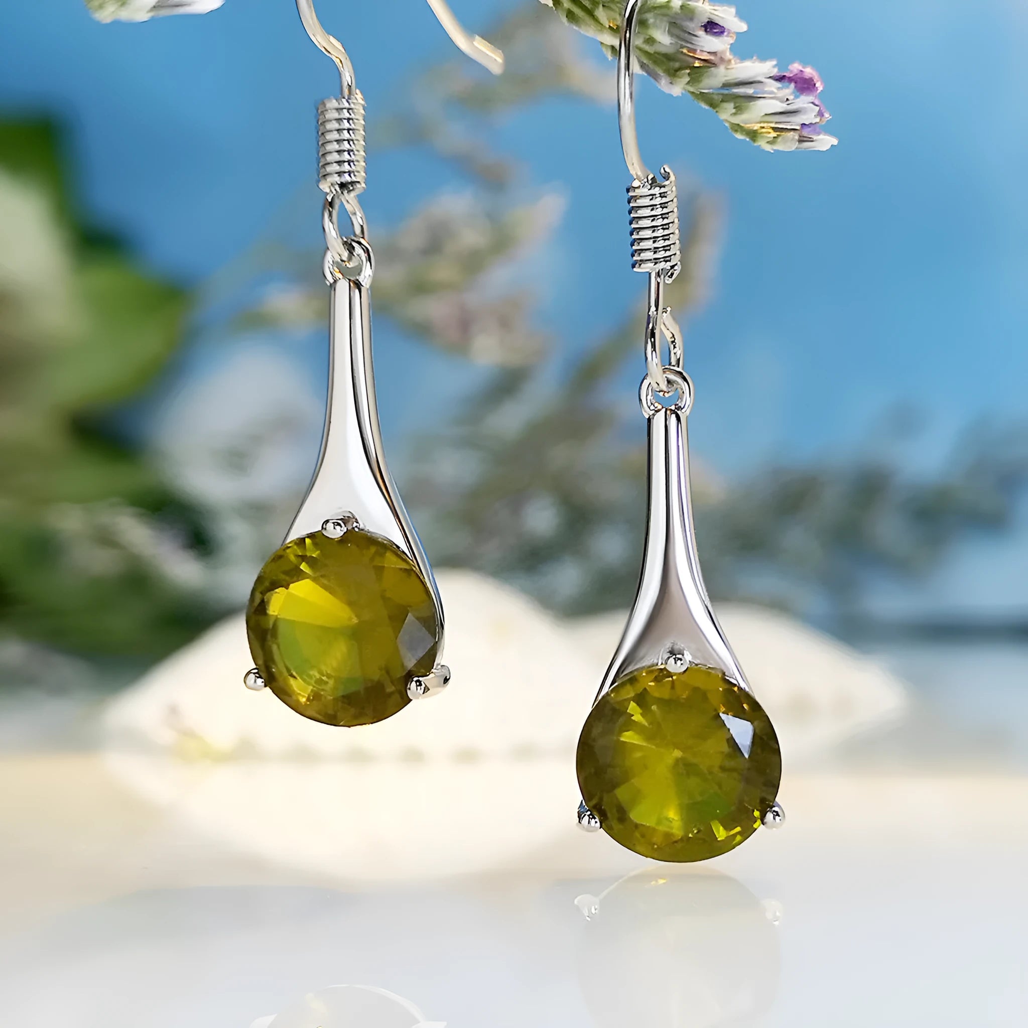 Olive green topaz coloured drop earrings with a water drop shape and retro style on a white background.