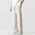 Man wearing beige straight-leg linen bamboo fibre trousers with a drawstring waist and cropped ankle length.