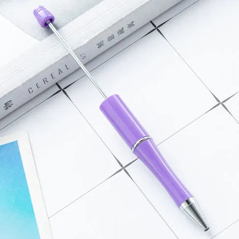 Colourful spinning ballpoint pen with plastic beads on a white background.