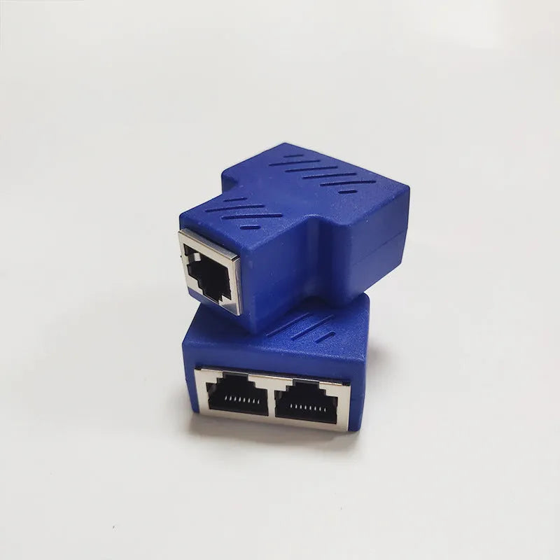 Two white RJ45 three-way tee network cable splitters on a surface