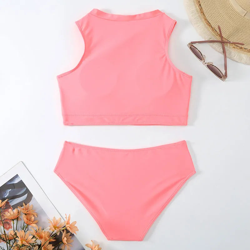 Pink high-waist bikini swimsuit with split shorts on a neutral background.