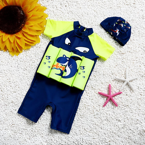 Child wearing a unisex buoyancy swimsuit with a cartoon shark design in a swimming pool.