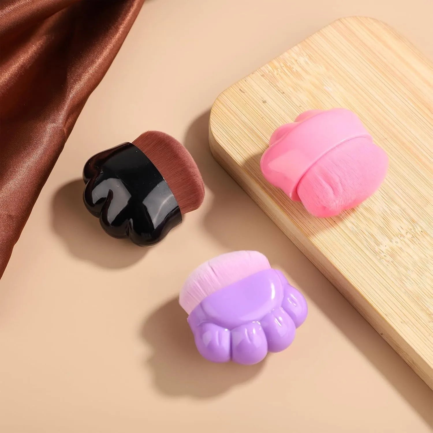 Three pet paw balm brushes with paw-shaped handles in individual storage boxes