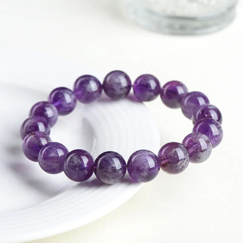 Natural feather amethyst bracelet with geometric Ruyi beads in snow mountain purple colour on a wrist.