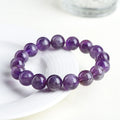 Natural feather amethyst bracelet with geometric Ruyi beads in snow mountain purple colour on a wrist.