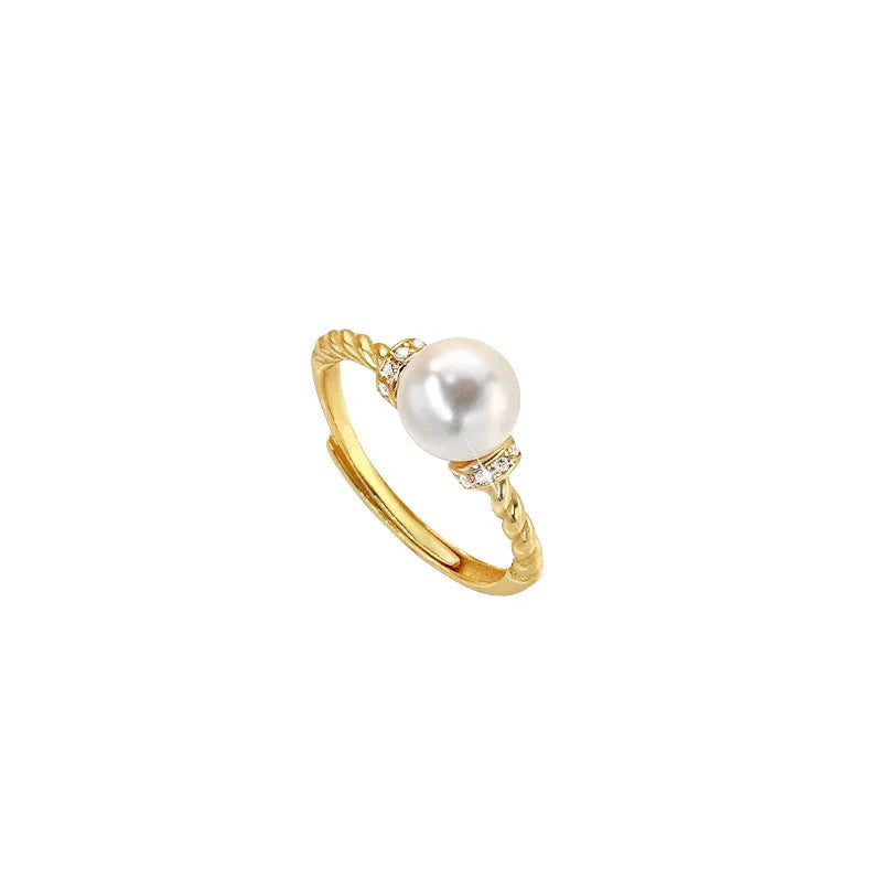 Adjustable antique-style copper ring with a round pearl inlaid in a geometric open frame on a twisted band.