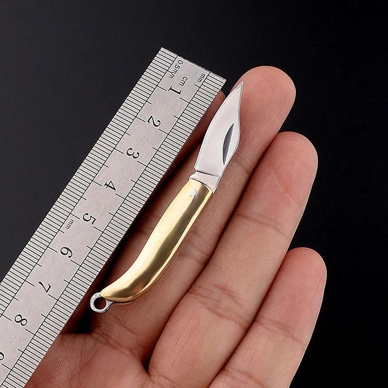 Brass mini folding knife keychain pendant with 3cm blade open showing brass body and compact size