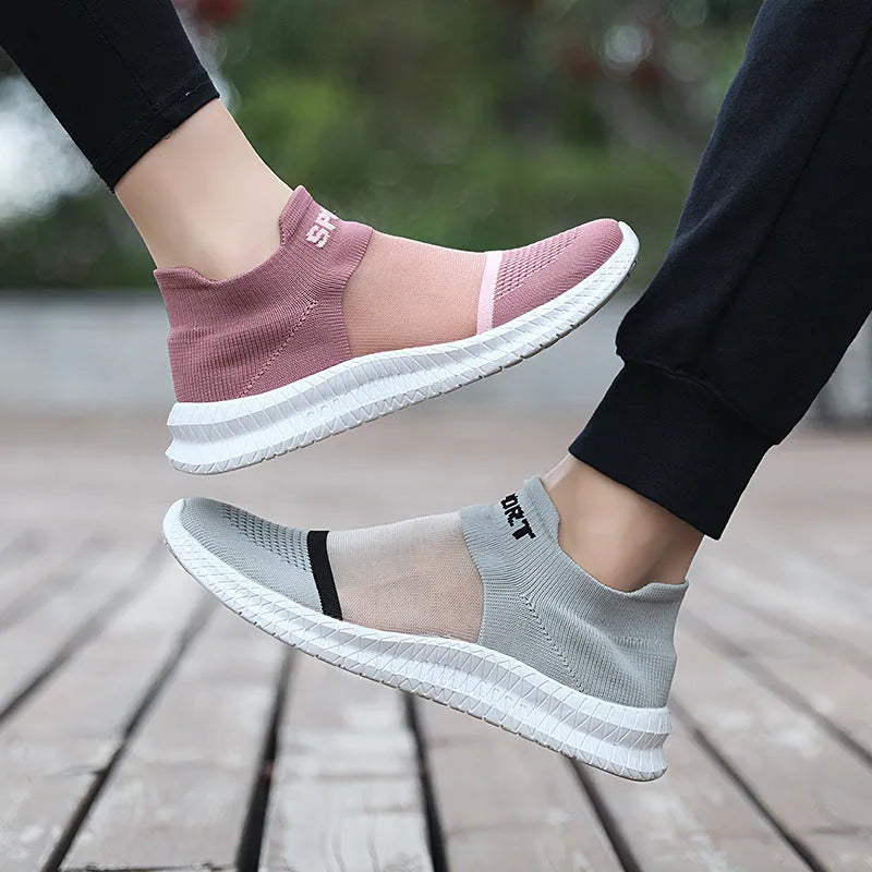 A pair of khaki Flyknit sock shoes with lace closure and a low-top design on an MD sole.
