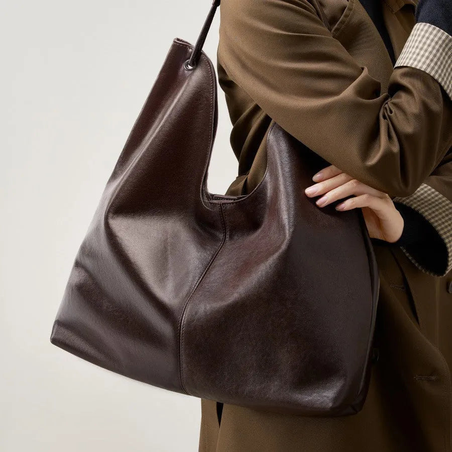 Brown genuine leather tote bag with contrast stitching and large capacity, front view on white background