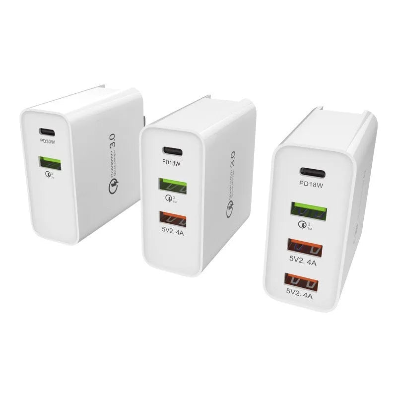 A white or black multi-port USB fast charger with PD and QC ports on a table.