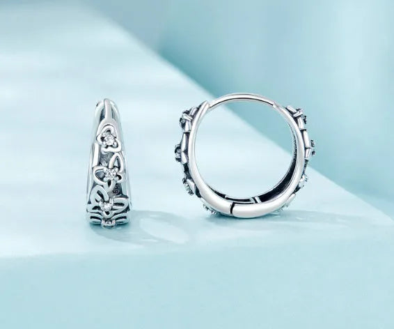 Close-up of retro hollow butterfly shaped stud earrings in sterling silver with zircon stones.