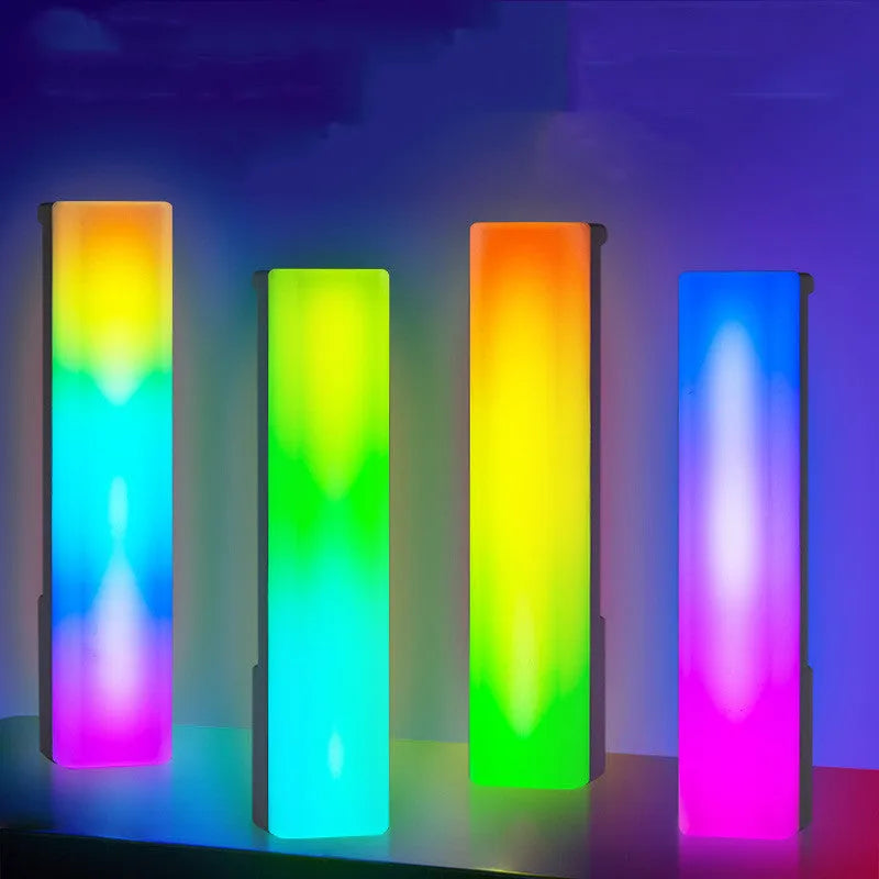A tall, colourful RGB table lamp with a white or black shell reacting to sound on a desk.