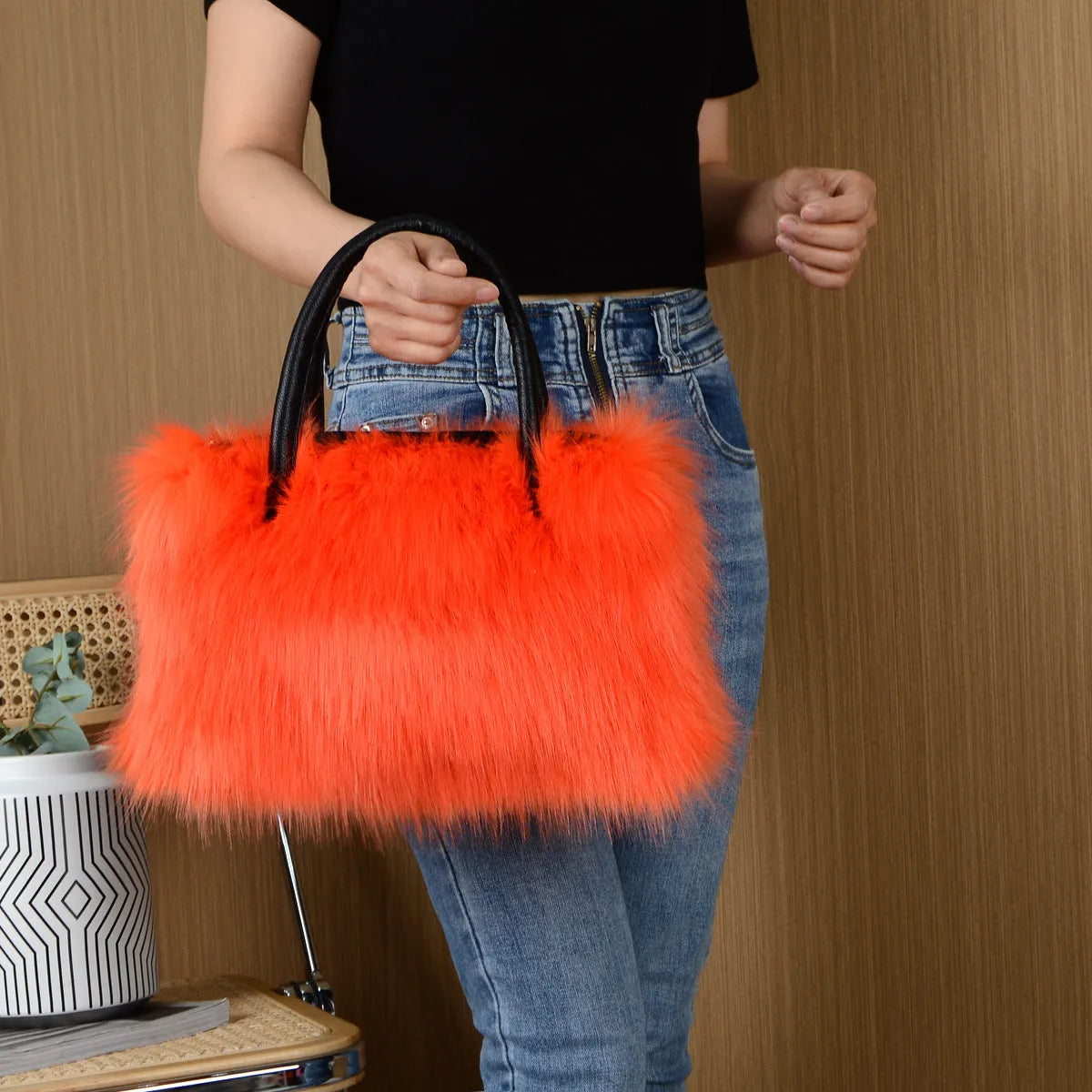 Hand-carrying square plush bag in pink with soft faux fur exterior and horizontal shape