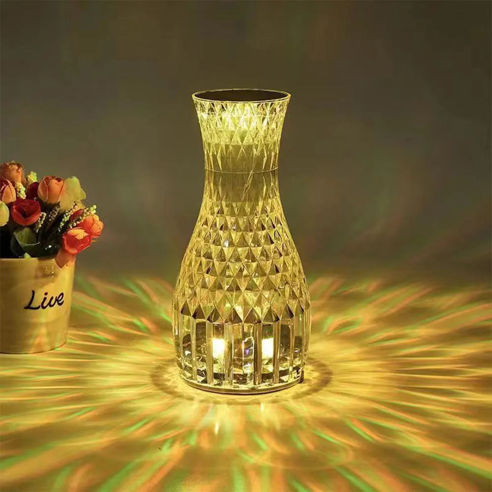 Vase-shaped crystal table lamp with LED lights and remote control on a bedside table