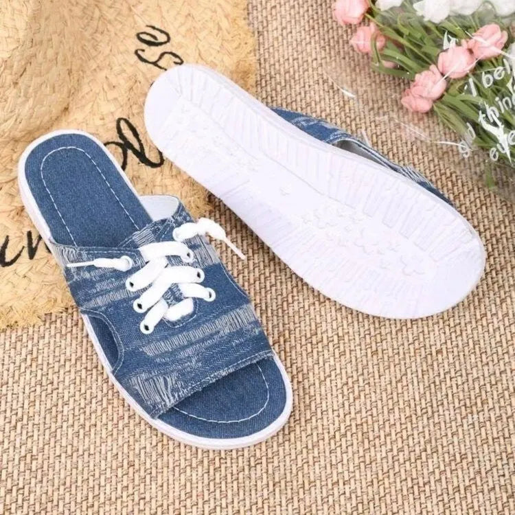 Blue Roman style women's flat canvas slippers with cloth upper and rubber sole.