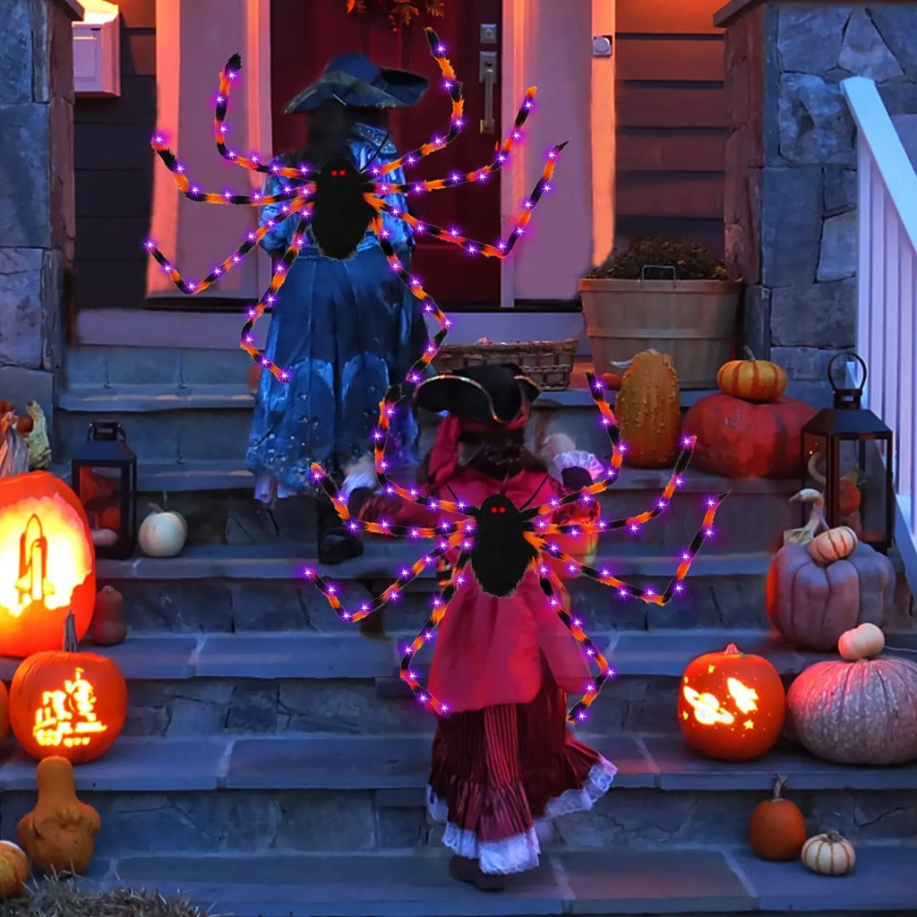 Orange plush Halloween spider backpack with purple LED lights lit up, showing the candy bag design.