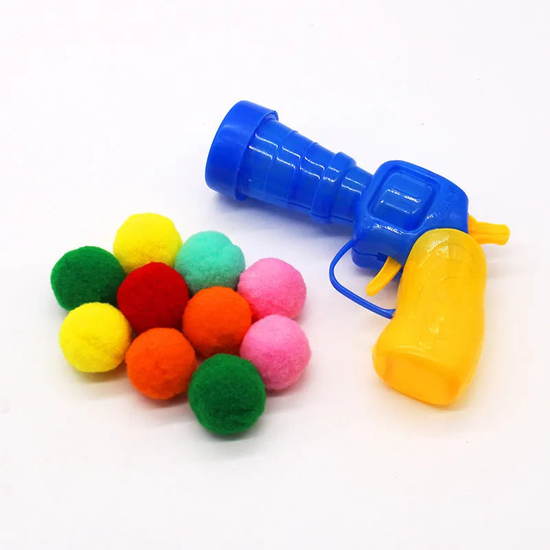 Pet toy set showing foam launch gun and assortment of soft plush balls for interactive fetch games