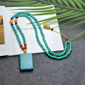 Turquoise stone lucky pendant necklace with detailed hand-woven mesh flower design on an adjustable ball bead chain.