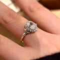 Geometric silver adjustable ring with an elliptical diamond on an index finger.