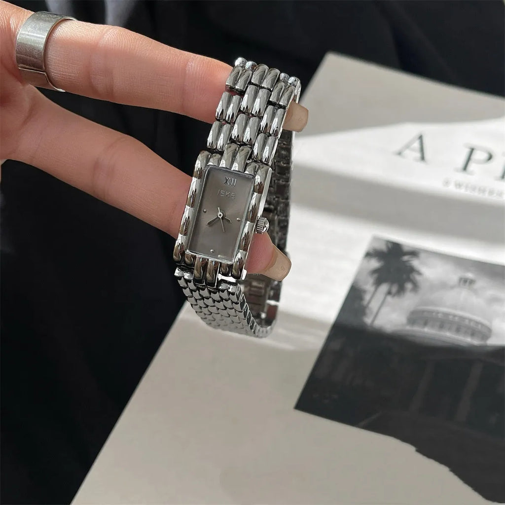 Women's stainless steel analogue watch with a butterfly clasp, showing a silver bracelet and white dial.