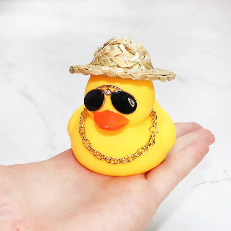 Yellow duck car ornament with straw hat and sunglasses on car dashboard