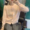 Women's cardigan sweater with a bow and pearl buttons in a solid colour.