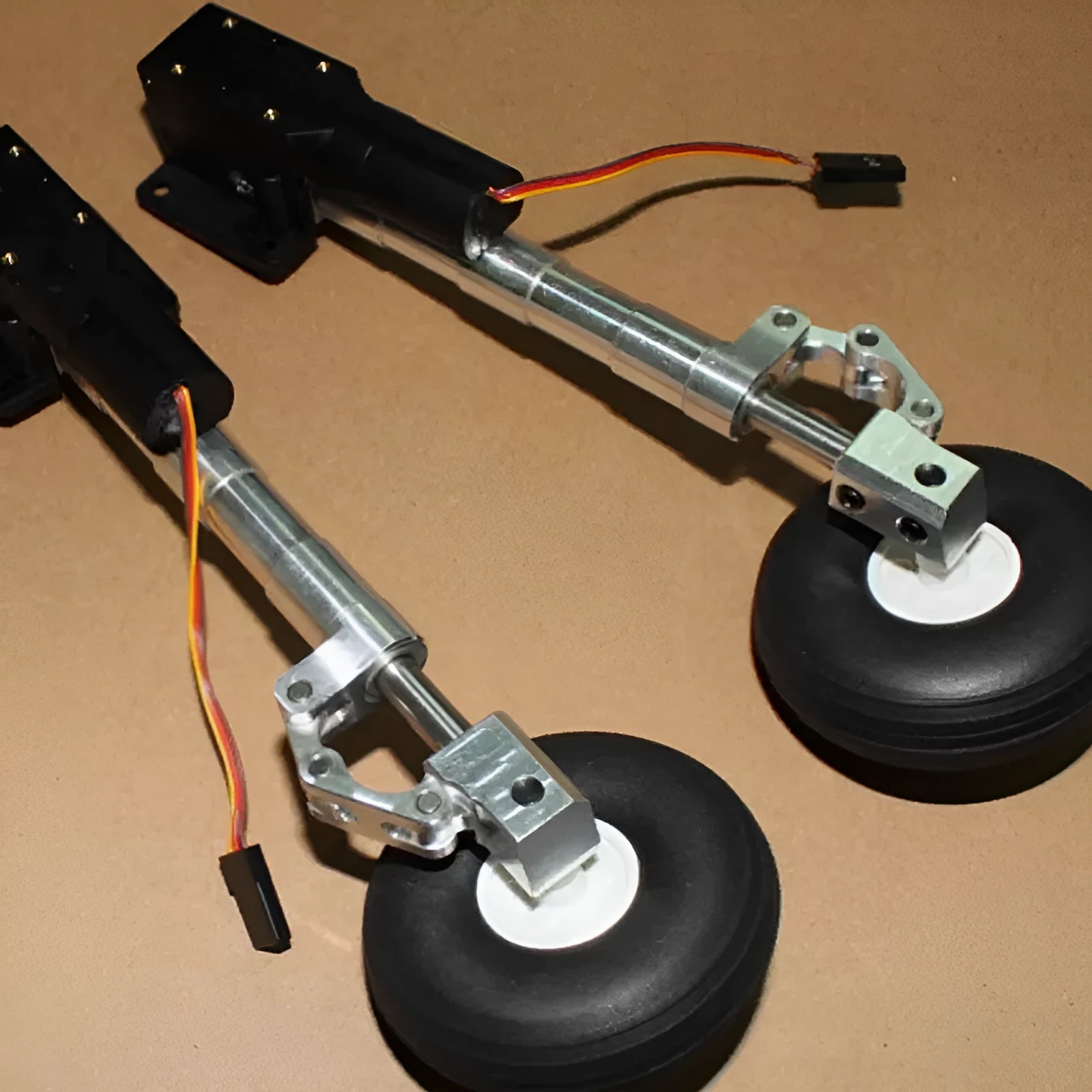 Alloy retractable shock-absorbing landing gear for RC toy aircraft with choice of wheels.