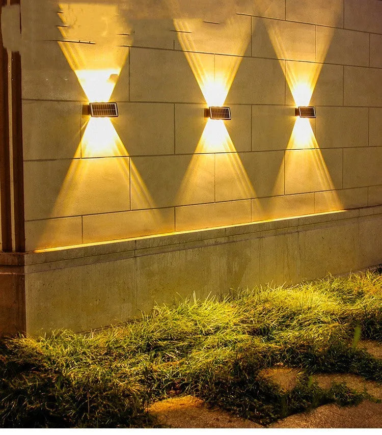 Solar outdoor wall light with 4 LED beads and glass polysilicon panel mounted on a garden wall