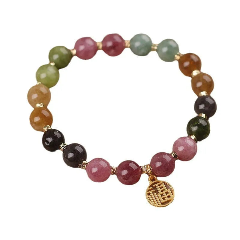 Natural colour tourmaline bracelet with silver electroplated flower and fu character charms on a geometric beaded band.