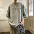 Men's grey loose-fit t-shirt with a raised retro letter print on the chest.