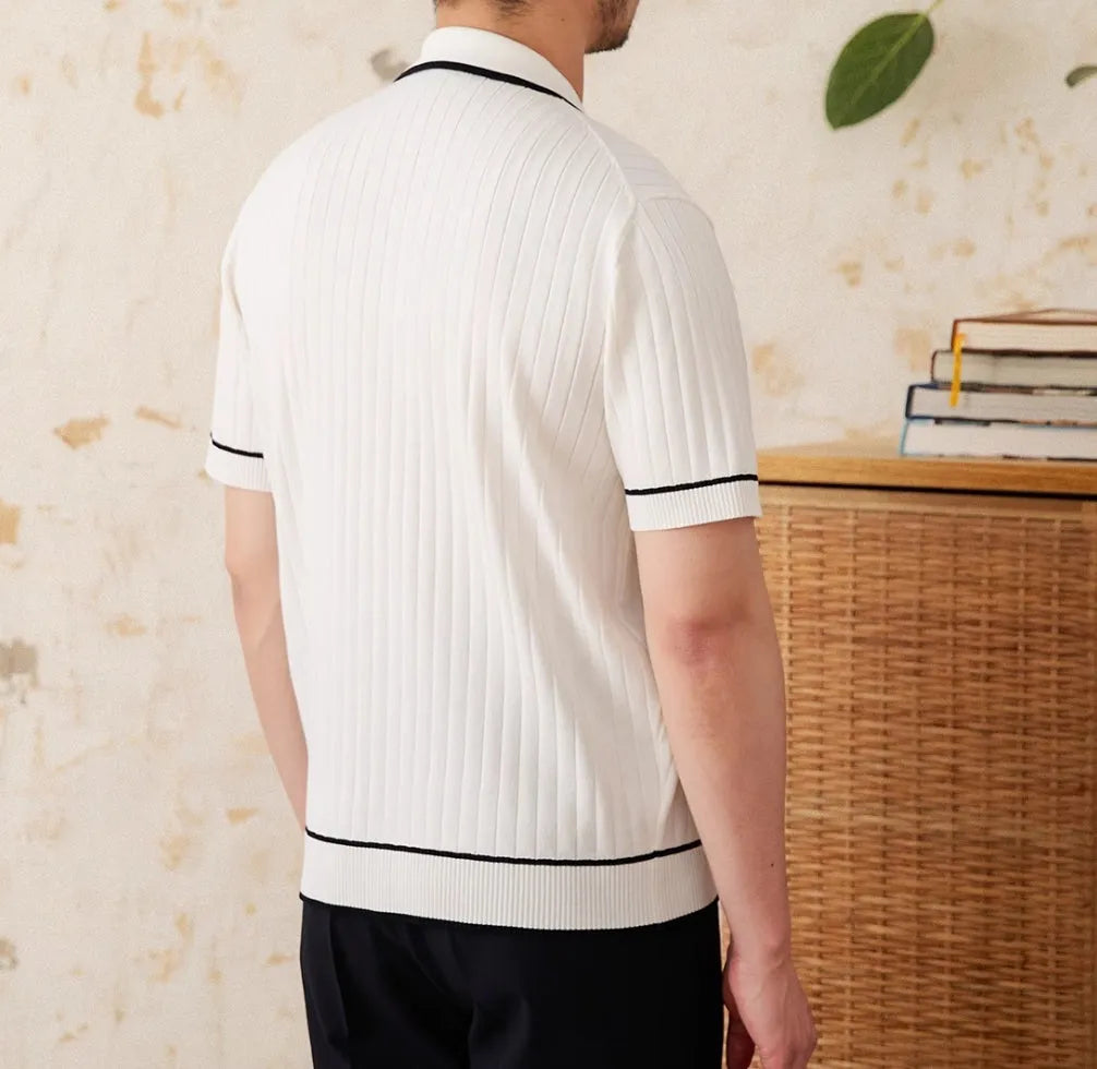 A black slim fit polo shirt with a lapel collar and short sleeves on a hanger.