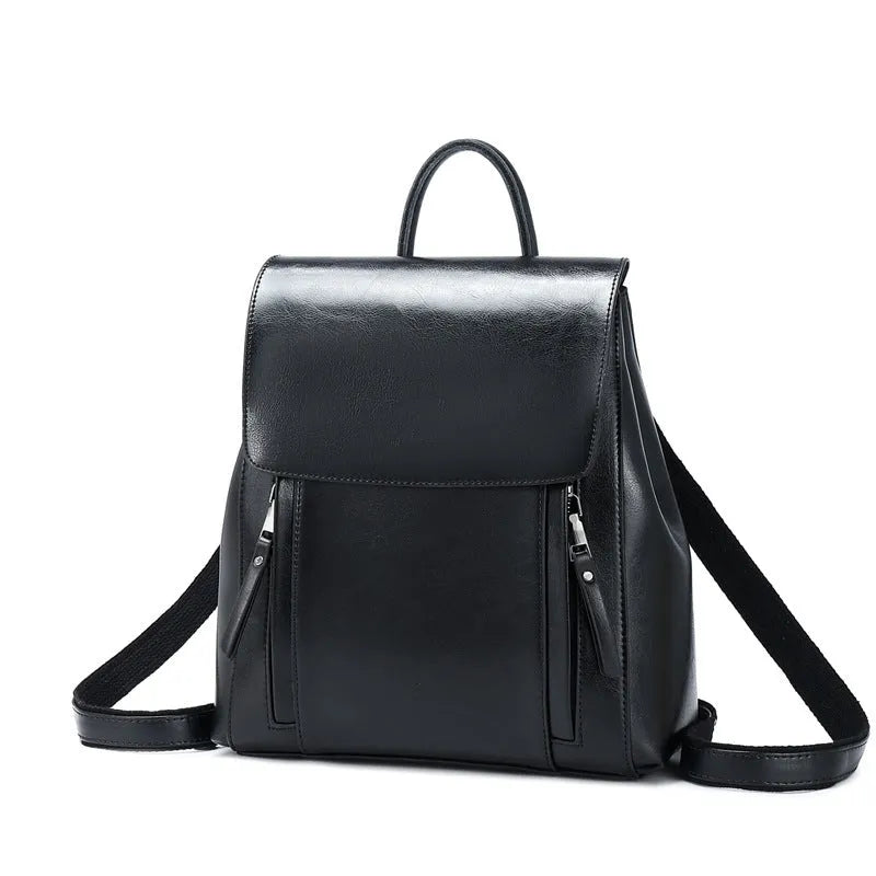 Genuine oil-waxed cowhide leather women's backpack in black, showing soft straps, cover flap, and clean stitching.