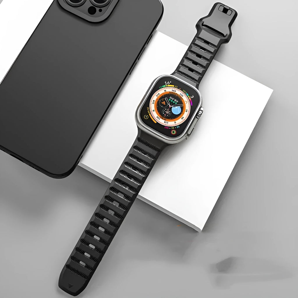 Black fluoro rubber Apple Watch band with silver T-buckle on a wrist, showing lightweight sport design.