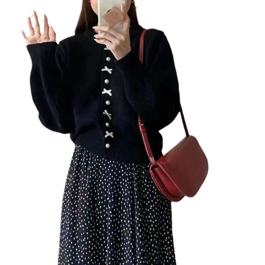 Women's cardigan sweater with a bow and pearl buttons in a solid colour.