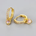 Women's heart-shaped earclip earrings with a coloured zircon or stone centre, in gold or white gold colour.